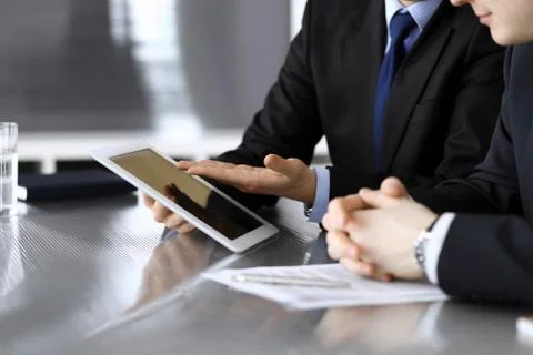 Businessman using tablet computer and work together with his colleague or Stock Photos