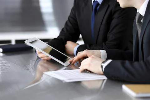 Businessman using tablet computer and work together with his colleague or Stock Photos
