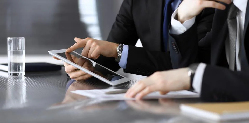 Businessman using tablet computer and work together with his colleague or Stock Photos
