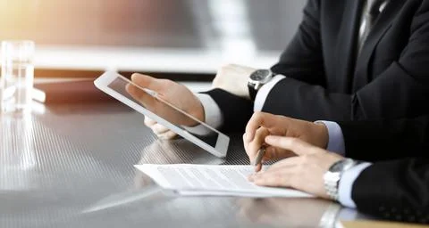 Businessman using tablet computer and work together with his colleague in sunny Stock Photos