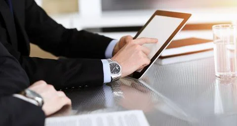 Businessman using tablet computer and work together with his colleague in sunny Stock Photos