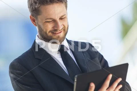 Businessman using tablet computer in city Stock Photos