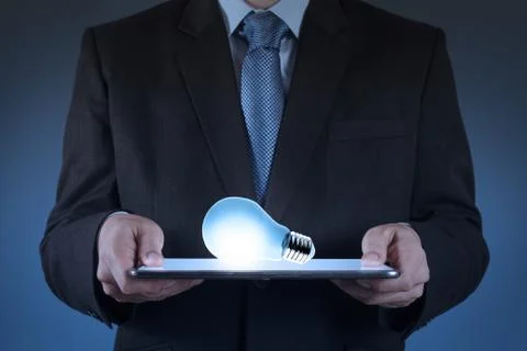 Businessman using tablet computer growing  light bulb as concept イラスト素材