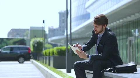 Businessman is using tablet computer near the  business center, car Parking Stock Footage 67583195