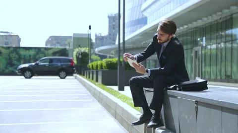 Businessman is using tablet computer near the business center, car Parking Vidéo 67583233