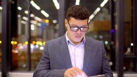 Businessman using tablet computer touchscreen in the night office. Stock Footage 87195196