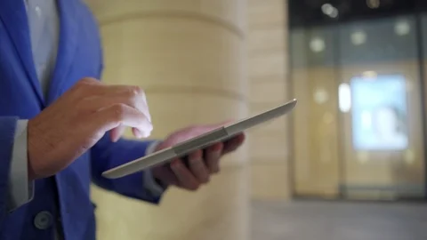 Businessman using tablet computer walking down street Stock Footage 100689560