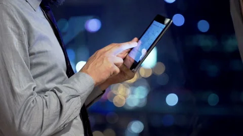 Businessman using tablet computer by window in office at night Stock Footage 56935778