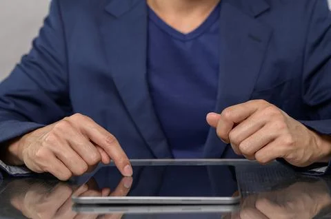 Businessman Using Tablet Device in Modern Workspace Setting Stock Photos