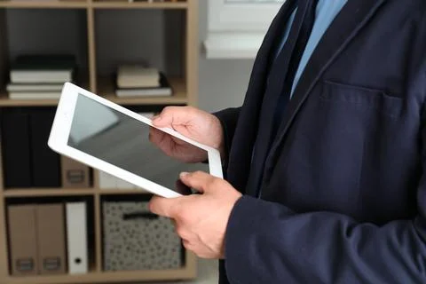 Businessman using tablet in office, closeup. Modern technology 스톡 사진