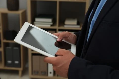 Businessman using tablet in office, closeup. Modern technology 스톡 사진