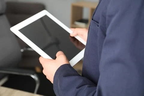 Businessman using tablet in office, closeup. Modern technology 写真素材