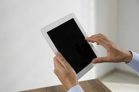 Businessman using tablet in office, closeup. Modern technology 库存照片