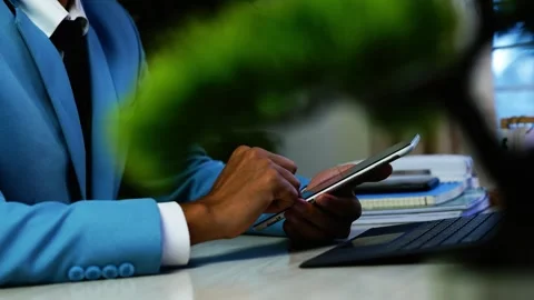 Businessman using tablet at office desk, Close view of a businessman in a b.. Stock Footage 348343793