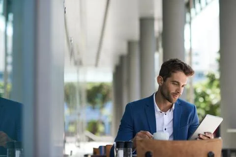 Businessman using a tablet over coffee at a sidewalk table Stock Photos