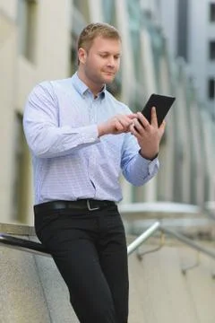 Businessman using a tablet pc against the background of office building Stock Photos