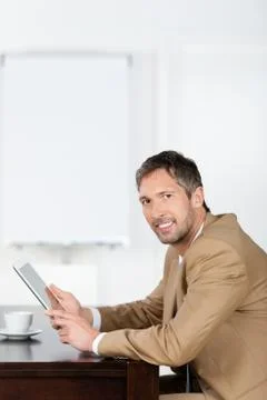 Businessman using tablet pc while sitting on desk Foto stock