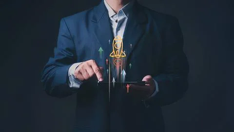 Businessman using tablet with rocket launch icon and arrows Stock Photos