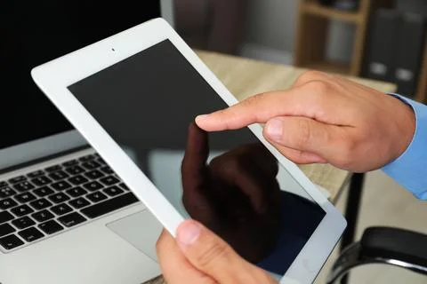 Businessman using tablet at table, closeup. Modern technology 스톡 사진
