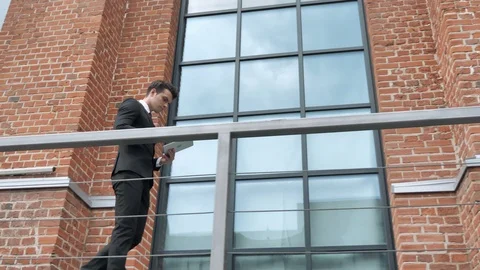 Businessman Using Tablet while Walking toward Loft Office Stock Footage 94853658