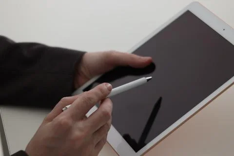 Businessman using tablet at white table, closeup. Modern technology Stock Photos