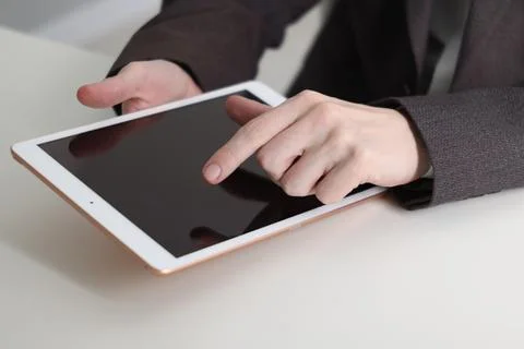 Businessman using tablet at white table indoors, closeup. Modern technology Stock Photos