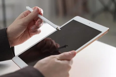 Businessman using tablet at white table indoors, closeup. Modern technology 写真素材