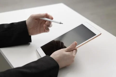 Businessman using tablet at white table indoors, closeup. Modern technology 스톡 사진