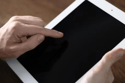 Businessman using tablet at wooden table, closeup. Modern technology 库存照片