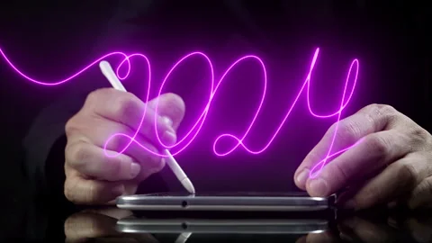 Businessman using tablet for writing virtual continuous line word of 2024 Stock Footage 258021381