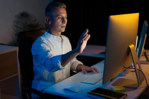 Businessman Using Touch-Free Computer Interface in Modern Office at Night Stock Photos