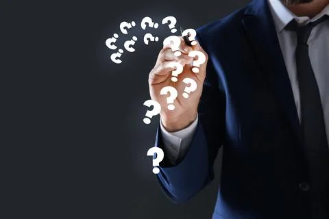 Businessman using virtual screen with question mark symbols on dark backgroun Foto stock