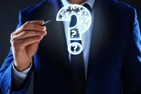 Businessman using virtual screen with question mark symbol on dark background Foto stock