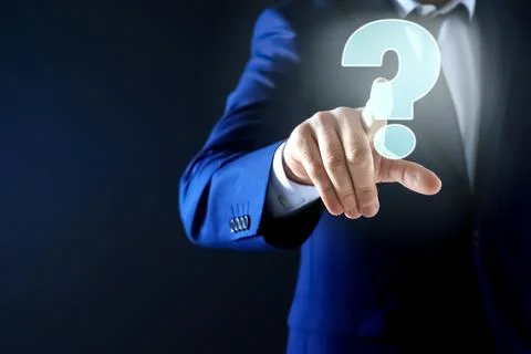 Businessman using virtual screen with question mark symbol on dark background Foto stock