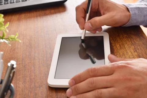 Businessman using white tablet with black screen in office Stock Photos