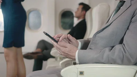 Businessman using wifi texting or playing mobile phone sitting in airplane he's Stock Footage 151314487