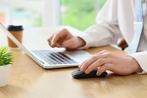 Businessman using wireless mouse and laptop at desk Stock Photos