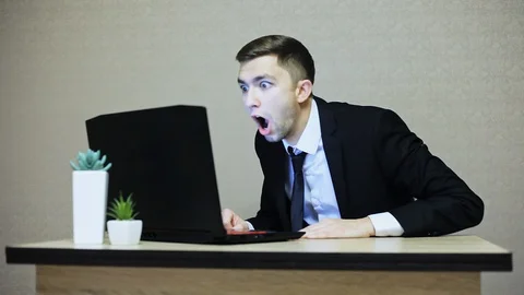 Businessman very surprised while working at a laptop in the office Stock Footage 99747935