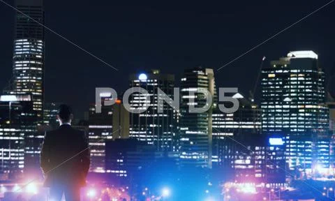Businessman viewing night glowing city Stock Photos
