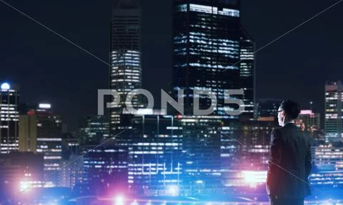 Businessman viewing night glowing city Stock Photos