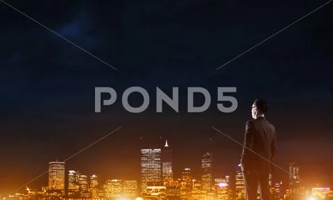 Businessman viewing night glowing city Stock Photos
