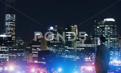 Businessman viewing night glowing city Stock Photos