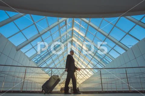 The businessman walk with a suitcase in the business center Stock Photos