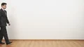 The businessman walking with a bag on a white wall background 4k or 4k+ Resolution