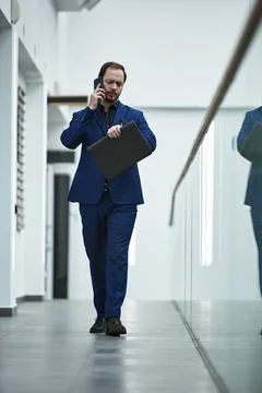 Businessman Walking in Corridor While Talking on Phone Stock Illustration