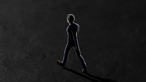 Businessman walking on a dark background Stock Footage 310793615