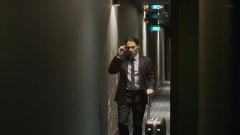 Businessman Walking down Hotel Corridor with Suitcase on Business Trip Stock Footage 342128116