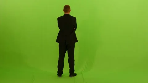 Businessman walking into the frame. standing against green screen background Видео 64800595