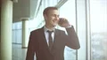 The businessman walking in the office hall and phoning. slow motion 4k or 4k+ Resolution