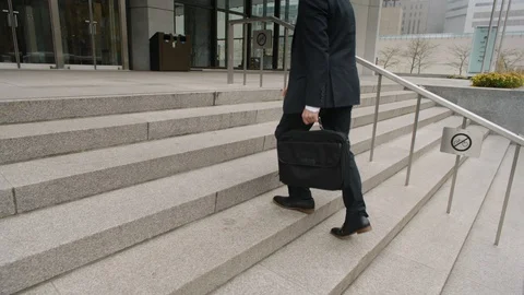 Businessman walking up steps with briefcase towards building entrance Vídeos de archivo 123883953